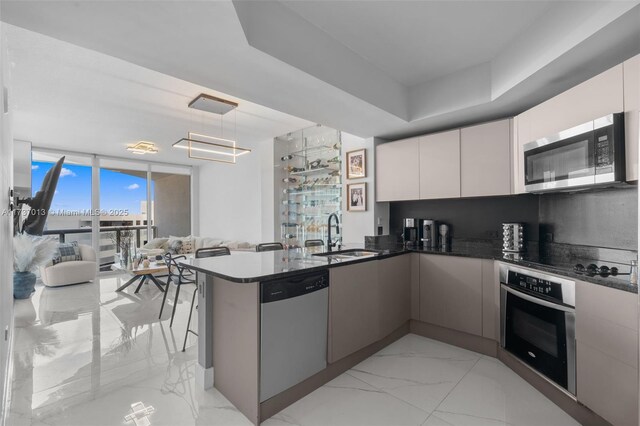 kitchen featuring sink, white cabinetry, dark stone counters, kitchen peninsula, and stainless steel appliances