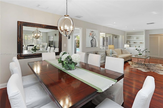 dining area featuring an inviting chandelier, wood-type flooring, and built in features