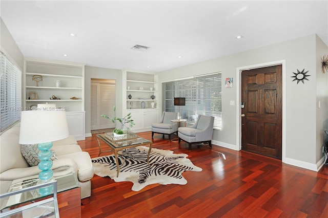 living room with dark hardwood / wood-style floors and built in shelves