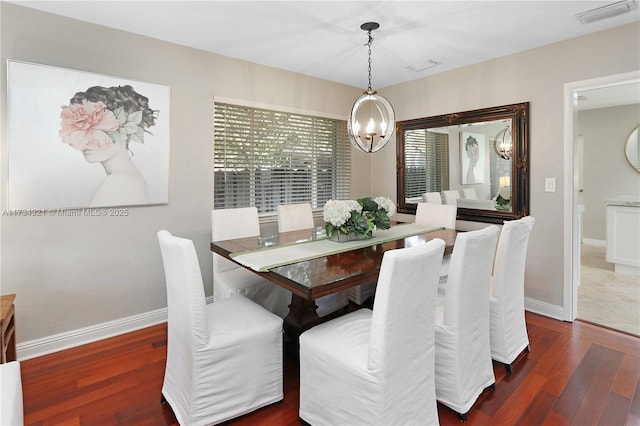 dining area with dark hardwood / wood-style flooring and a notable chandelier