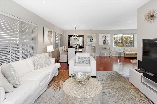 living room with wood-type flooring and an inviting chandelier