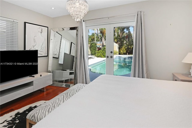 bedroom featuring dark wood-type flooring, access to exterior, french doors, and a notable chandelier