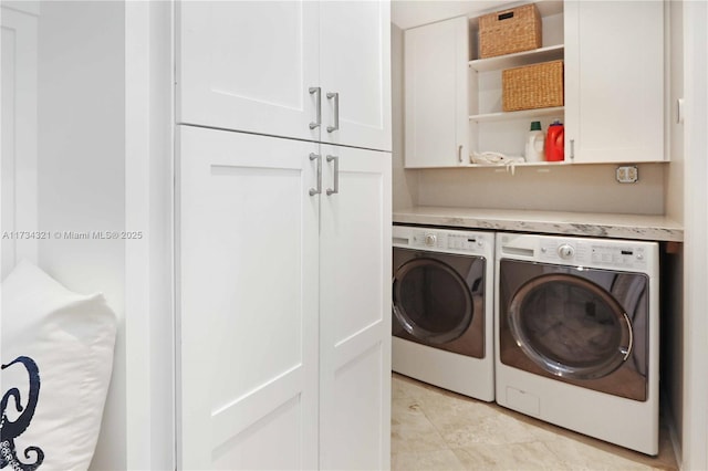 laundry room with cabinets, light tile patterned flooring, and washer and dryer