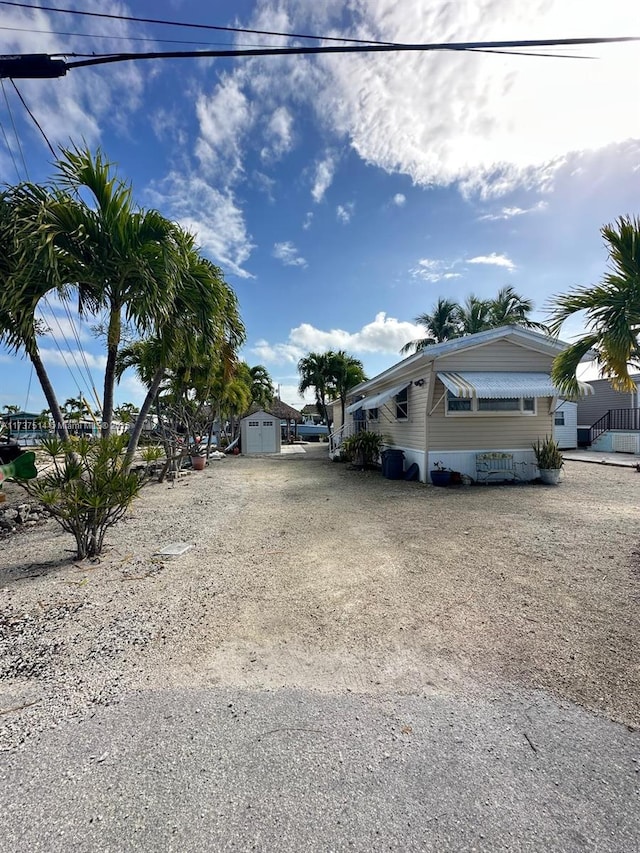 view of side of home with an outdoor structure and driveway