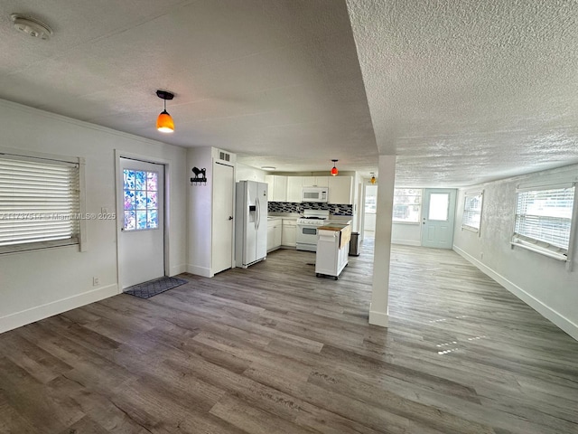 unfurnished living room with baseboards, dark wood-style flooring, and a textured ceiling