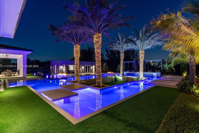 pool at twilight featuring an outdoor structure, a jacuzzi, a patio area, and a lawn