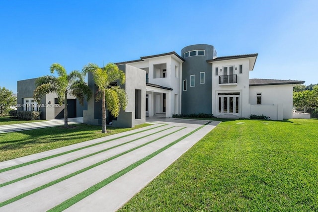 view of front of house featuring a front yard, french doors, and a balcony