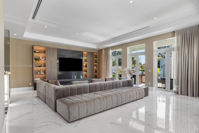 living room with a raised ceiling and french doors