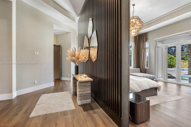 bedroom featuring hardwood / wood-style flooring, a notable chandelier, french doors, and access to outside