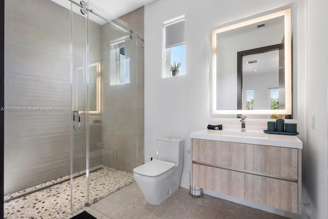 bathroom with walk in shower, vanity, tile patterned floors, and toilet