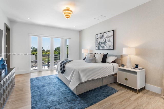 bedroom with access to exterior, light wood-type flooring, and french doors