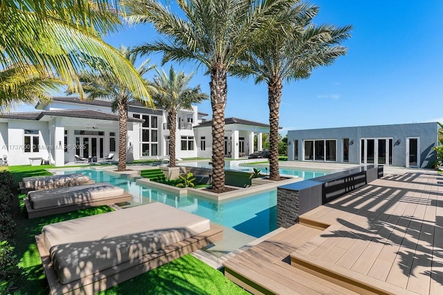 view of swimming pool with french doors and a deck