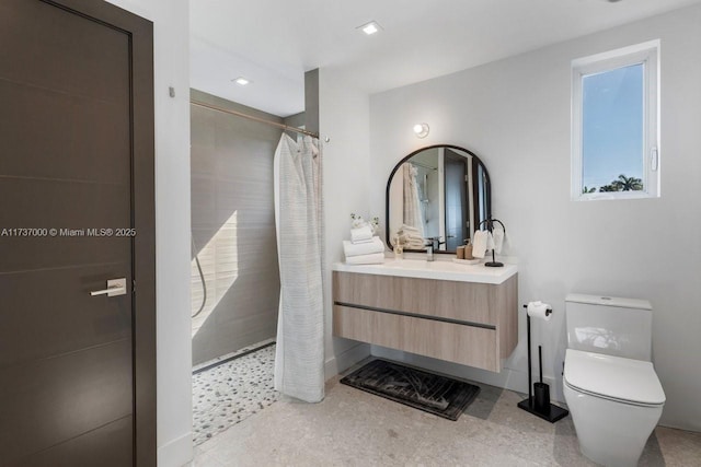 bathroom featuring vanity, toilet, and walk in shower