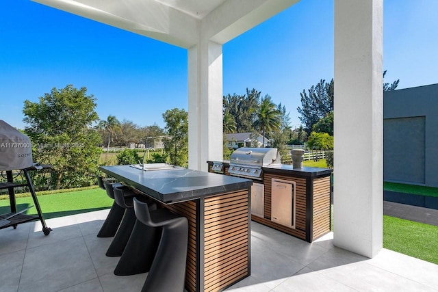 view of patio with a bar, grilling area, and exterior kitchen