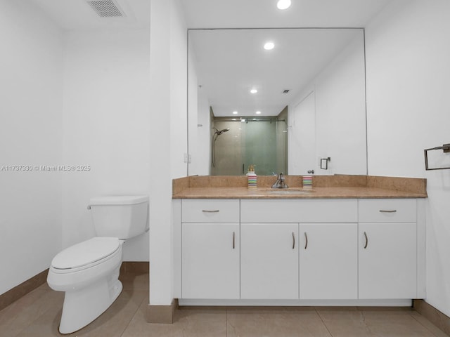 bathroom featuring vanity, a shower with shower door, tile patterned floors, and toilet