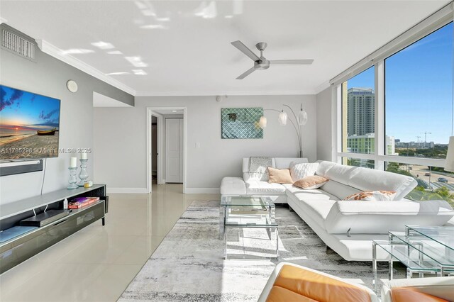 tiled living room featuring ornamental molding, ceiling fan, and a wall of windows