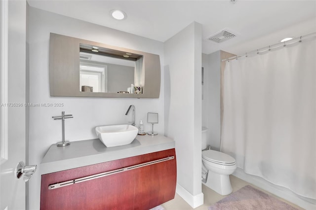 full bathroom with vanity, shower / bath combo, and toilet