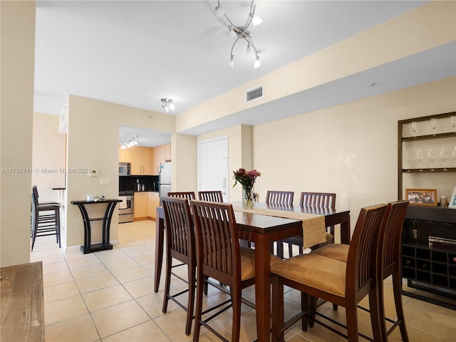 dining space with light tile patterned floors and track lighting