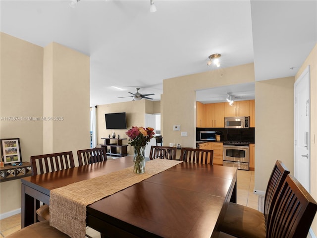 tiled dining space featuring ceiling fan