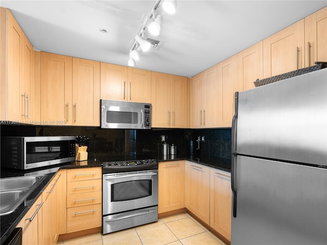 kitchen with light tile patterned floors, light brown cabinets, and appliances with stainless steel finishes