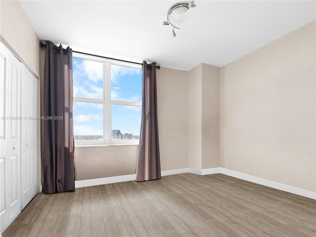 unfurnished bedroom featuring light hardwood / wood-style floors and a closet