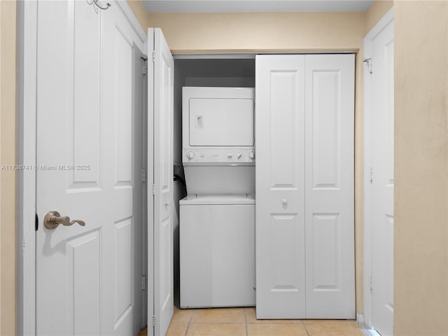 clothes washing area featuring stacked washer / drying machine and light tile patterned floors