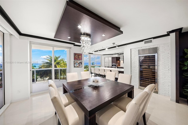 dining room with crown molding, beverage cooler, light tile patterned flooring, and a notable chandelier