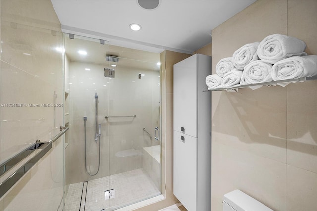 bathroom with toilet and a shower with shower door