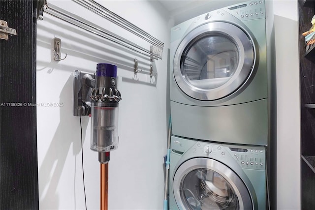 clothes washing area with stacked washer and clothes dryer