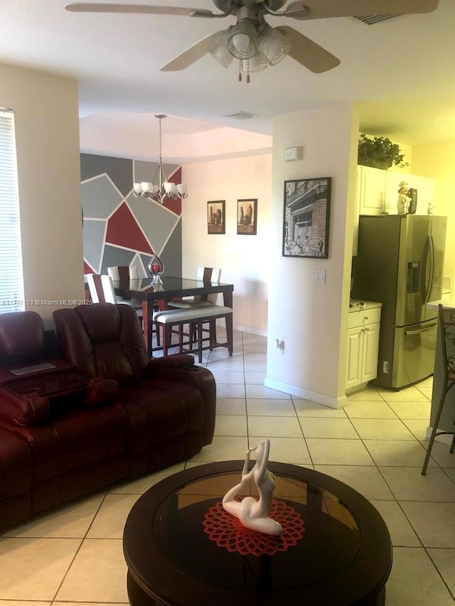 living room with light tile patterned floors and ceiling fan with notable chandelier