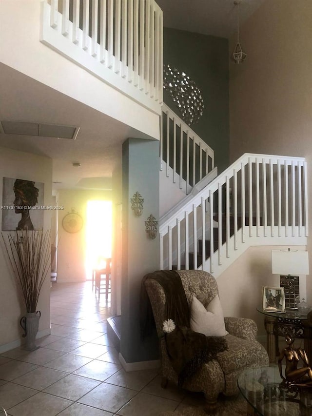 staircase with a towering ceiling and tile patterned flooring