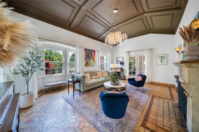 living room featuring coffered ceiling, crown molding, french doors, and a chandelier