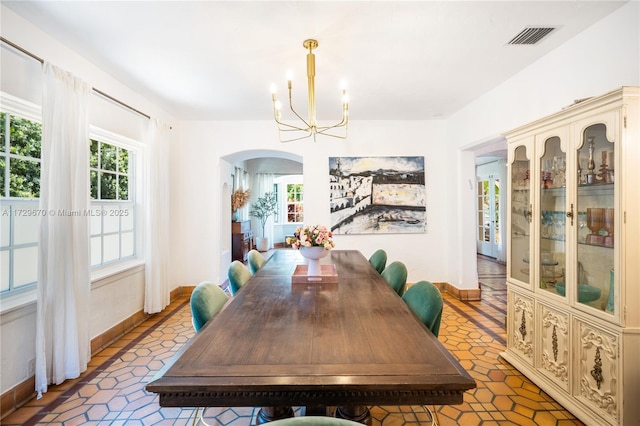 2424 Prairie Ave, Miami Beach, FL 33140 - dining area with arched walkways, a chandelier, plenty of natural light, and tile patterned flooring