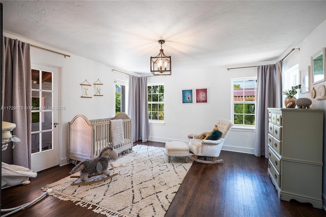 sitting room with dark wood-type flooring, a chandelier, and plenty of natural light