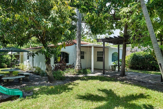 2424 Prairie Ave, Miami Beach, FL 33140 - back of house with stucco siding, a yard, and a tile roof