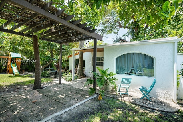 view of patio / terrace with a pergola and a playground