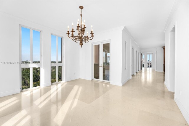 spare room with crown molding, french doors, and a notable chandelier