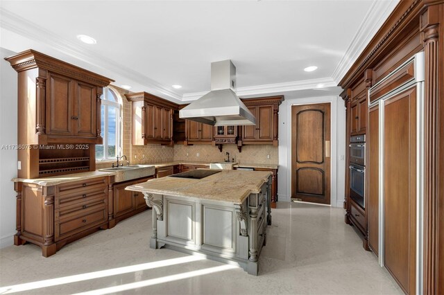 kitchen with a breakfast bar area, crown molding, island range hood, a kitchen island, and light stone countertops