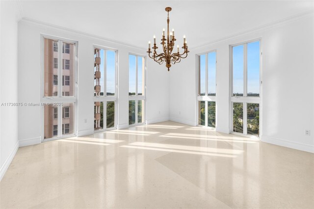 unfurnished room with a wealth of natural light, ornamental molding, and a chandelier