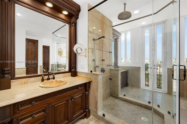 bathroom with tile walls, vanity, and walk in shower