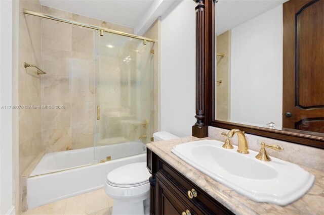 full bathroom featuring shower / bath combination with glass door, tile patterned floors, vanity, and toilet