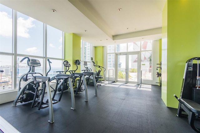 exercise room featuring expansive windows, plenty of natural light, and french doors