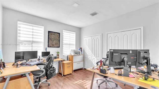 office area featuring visible vents and light wood-style flooring