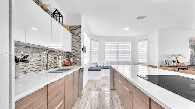 kitchen featuring dishwasher, modern cabinets, black electric cooktop, and a sink