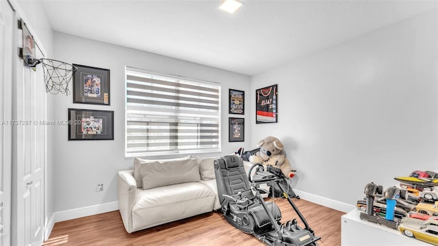 living area featuring light wood finished floors and baseboards