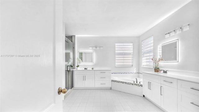 full bath with a garden tub, two vanities, a sink, and tile patterned flooring