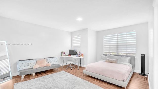 bedroom with baseboards and wood finished floors