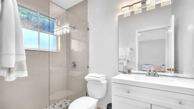 bathroom featuring vanity, a shower stall, and toilet