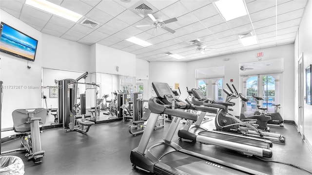 exercise room featuring a paneled ceiling, ceiling fan, visible vents, and french doors