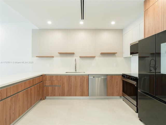 kitchen featuring white cabinetry, stainless steel dishwasher, sink, and stove